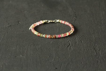 Chrome diopside bracelet. A bracelet made of stones on a hand from natural stone Chrome diopside. Bracelet made of natural stones. Handmade jewelry. Handmade bracelets on light modern background.の写真素材