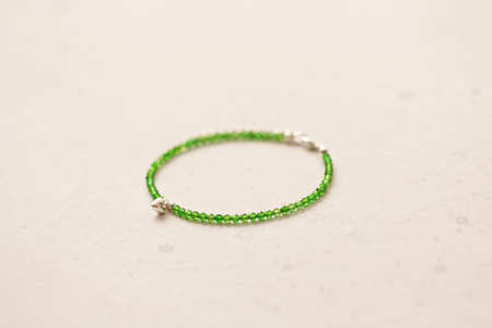 Chrome diopside bracelet. A bracelet made of stones on a hand from natural stone Chrome diopside. Bracelet made of natural stones. Handmade jewelry. Handmade bracelets on light modern background.の写真素材