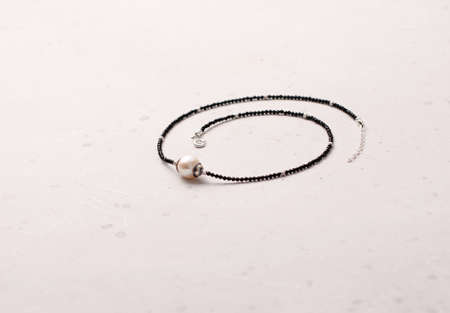 Bright delicate multi-colored tourmaline, moonstone bracelet rests on black modern concrete background. Bracelet made of stones on hand. Handmade bracelets on black modern background. LGBT bracelet.の写真素材