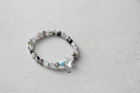 Bright delicate multi-colored tourmaline, moonstone bracelet rests on black modern concrete background. Bracelet made of stones on hand. Handmade bracelets on black modern background. LGBT bracelet.の写真素材