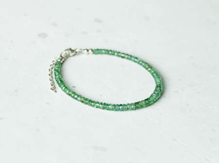 Bright delicate multi-colored tourmaline, moonstone bracelet rests on black modern concrete background. Bracelet made of stones on hand. Handmade bracelets on black modern background. LGBT bracelet.の写真素材