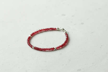 Bright delicate multi-colored tourmaline, moonstone bracelet rests on black modern concrete background. Bracelet made of stones on hand. Handmade bracelets on black modern background. LGBT bracelet.の写真素材