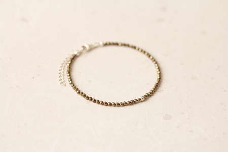 Bright delicate multi-colored tourmaline, moonstone bracelet rests on black modern concrete background. Bracelet made of stones on hand. Handmade bracelets on black modern background. LGBT bracelet.の写真素材