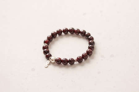 Bright delicate multi-colored tourmaline, moonstone bracelet rests on black modern concrete background. Bracelet made of stones on hand. Handmade bracelets on black modern background. LGBT bracelet.の写真素材