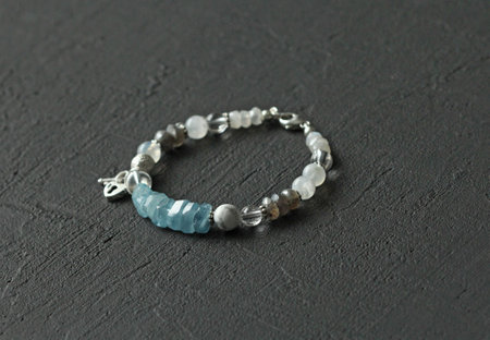 Bright multicolored bracelet. Ruby, coral, carnelian, citrine, emerald, apatite, amazonite, turquoise, lapis lazuli, tanzanite, black spinel. Handmade jewelry bracelets on light modern background.の写真素材