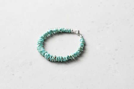 Bright multicolored bracelet. Ruby, coral, carnelian, citrine, emerald, apatite, amazonite, turquoise, lapis lazuli, tanzanite, black spinel. Handmade jewelry bracelets on light modern background.の写真素材