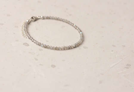 Bright multicolored bracelet. Ruby, coral, carnelian, citrine, emerald, apatite, amazonite, turquoise, lapis lazuli, tanzanite, black spinel. Handmade jewelry bracelets on light modern background.の写真素材