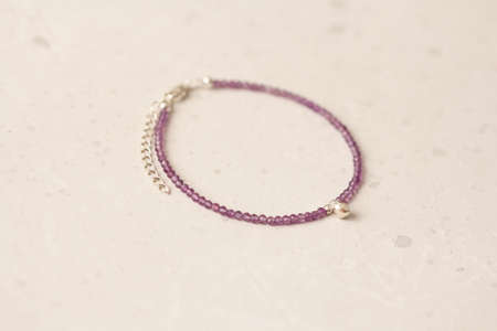 Bright multicolored bracelet. Ruby, coral, carnelian, citrine, emerald, apatite, amazonite, turquoise, lapis lazuli, tanzanite, black spinel. Handmade jewelry bracelets on light modern background.の写真素材