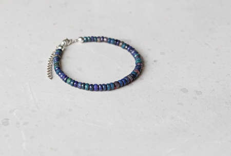 Bright multicolored bracelet. Ruby, coral, carnelian, citrine, emerald, apatite, amazonite, turquoise, lapis lazuli, tanzanite, black spinel. Handmade jewelry bracelets on light modern background.の写真素材