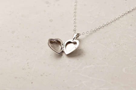 Open Medallion pendant in shape of heart made of silver on chain. Love, romance, beautiful romantic gift heart medallion pendant, jewelry on the girl. Heart-shaped medallion pendant, silver.の写真素材