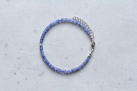 Tanzanite bracelet. Bracelet made of stones on hand from natural stone Tanzanite. Bracelet made of natural stones. Handmade jewelry. Handmade bracelets on light modern background.の写真素材