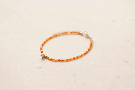 Carnelian bracelet. Bracelet made of stones on hand from natural stone Carnelian. Bracelet made of natural stones. Handmade jewelry. Handmade bracelets on light modern background.の写真素材