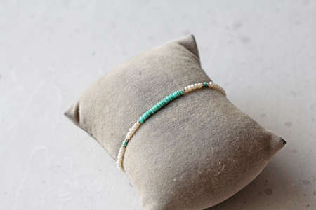 Turquoise and pearls bracelet. Bracelet made of stones on hand from natural stone Turquoise pearls. Bracelet made of natural stones. Handmade jewelry. Handmade bracelets on light modern background.の写真素材