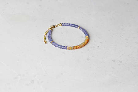 Tanzanite, fire opal bracelet. Bracelet made stones on hand from natural stone Tanzanite, fire opal. Bracelet made of natural stones. Handmade jewelry. Handmade bracelets on light modern background.の写真素材