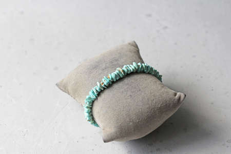 Turquoise bracelet. Bracelet made of stones on hand from natural stone Turquoise. Bracelet made of natural stones. Handmade jewelry. Handmade bracelets on light modern background.の写真素材