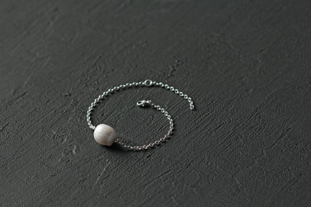 Natural Kasumi White pearls bracelet on silver chain. Bracelet made from Natural Kasumi pearls. Handmade pearls bracelets on black modern background. Designer jewelry, bracelet with kasumi pearl.の写真素材