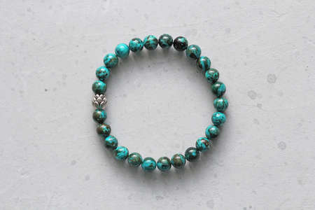 Chrysocolla bracelet. Bracelet made of stones on hand from natural stone Chrysocolla. Bracelet made of natural stones. Author's handmade jewelry. Handmade bracelets on light modern background.の写真素材
