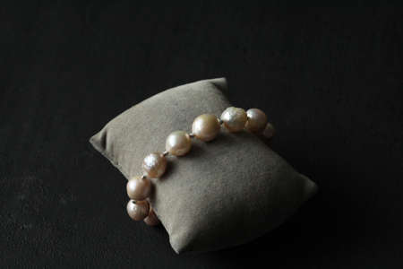 Natural Kasumi pearls bracelet. Bracelet made of stones on hand from Natural Kasumi pearls. Bracelet made of natural pearls. Handmade jewelry. Handmade pearls bracelets on black modern background.の写真素材