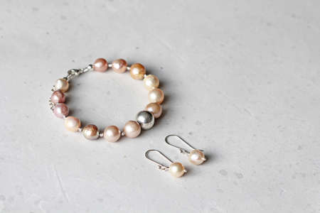 Bracelet, earrings Kasumi pearls. A bracelet made of on a hand from natural stone Kasumi pearls. Bracelet, earrings made of natural pearls. Handmade jewelry. Jewelry set bracelet and earrings.の写真素材