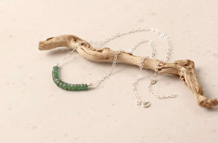 Emerald stones on silver chain necklace Pendant. Handmade Short necklace on a girl made of natural stones Emerald. Modern jewelry. Green emerald stones on silver chain, choker on neck of stones.の写真素材