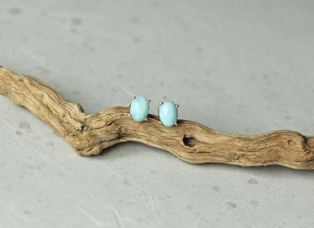 Stud earrings made of natural larimar. Designer earrings from natural larimar stones. Women's jewelry on a light background and stone. Author's modern jewelry. Larimar jewelry earrings studs.の写真素材