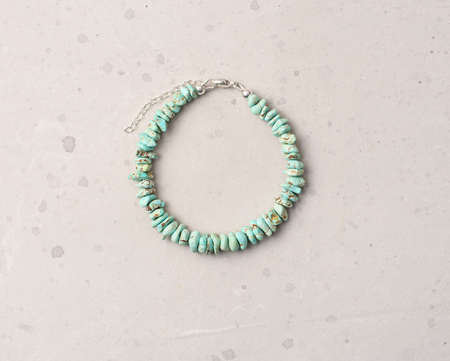 Turquoise bracelet. Bracelet made of stones on hand from natural stone Turquoise. Bracelet made of natural stones. Handmade jewelry. Handmade bracelets on light modern background.の写真素材