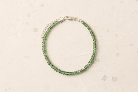 Emerald bracelet. Bracelet made of stones on hand from natural stone Emerald. Bracelet made of natural stones. Handmade jewelry. Handmade bracelets on light modern background.の写真素材