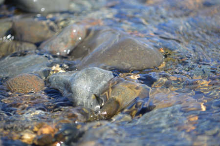 Water flowing over pebbles at a beach