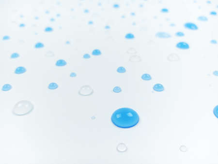 Selective focus of blue and clear water drops on white background with blurred effect.