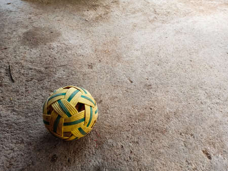 rattan ball with soft blurry cement background.