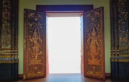 Golden Thai pattern door opened to white light. The gateway to heaven.