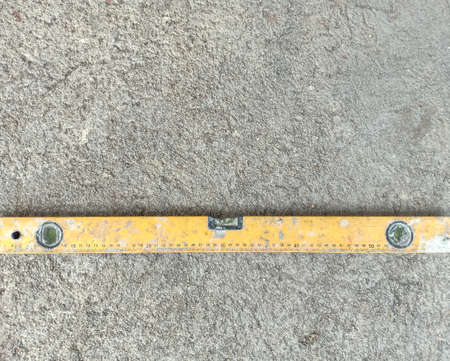 Yellow rural usually use in construction put horizontal line on rough cement floor.