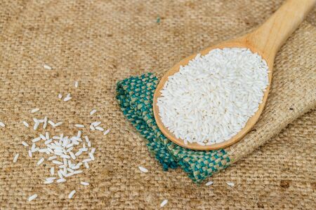 Glutinous rice in wooden spoon with hemp sacks backgroundの写真素材