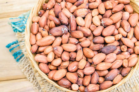 Raw peanuts or arachis on bamboo basket on sackの写真素材