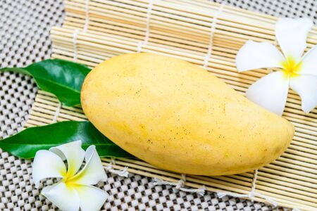 Single mango fruit with white plumeria flower