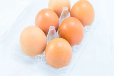 Raw chicken eggs in egg box on white backgroundの写真素材