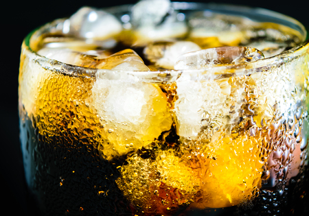 Cola glass with ice on black backgroundの写真素材