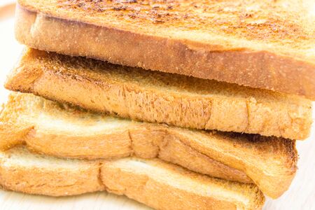 toasted bread on wooden plate isolated on white background