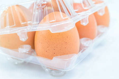 Raw chicken eggs in egg box on white backgroundの写真素材