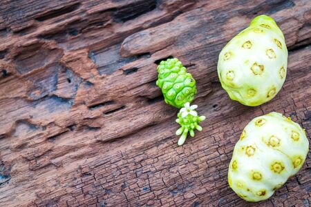 Noni fruit on old wooden tableの写真素材