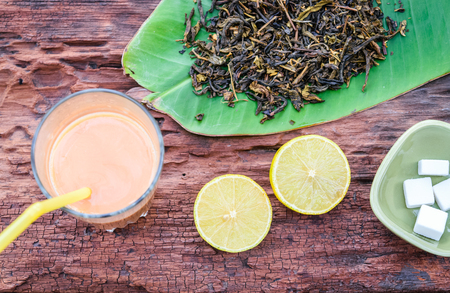 Tea with milk and lemon on old wood backgroundの写真素材