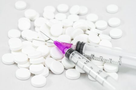 Medicines. Pills and injection needle on white backgroundの写真素材