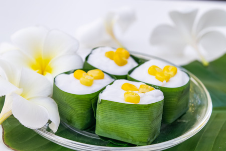 Thai coconut jelly in a pandan leaves cup with flowerの写真素材