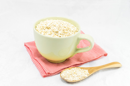Oat flakes in cup isolated on white background. Healthy food.の写真素材