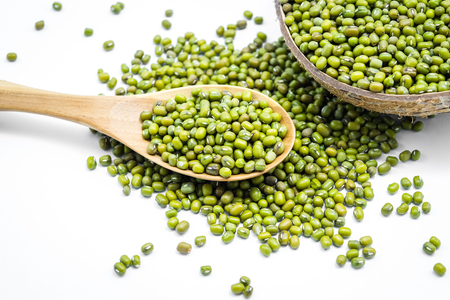 Organic mung beans with wooden spoon and coconut shell isolated on white backgroundの写真素材