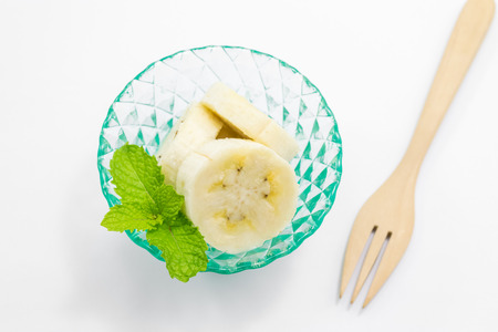 Ripe banana in a cup with peppermint isolated on white background.の写真素材