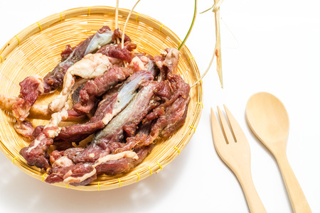 Dried meat in a bamboo dish on white background, Food preservation, Thai traditional food.の写真素材