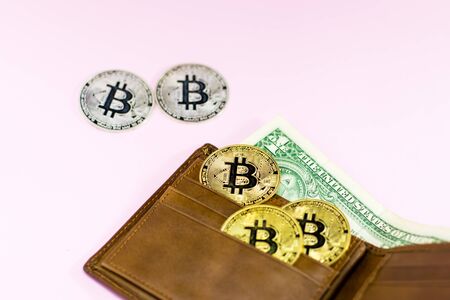 Bitcoin and leather wallet with one dollar bill isolated on pink background.