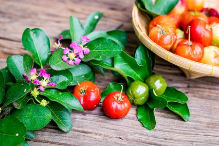 Fresh organic Acerola cherry on old wood background.の写真素材