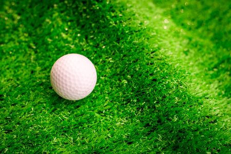 Golf ball on green grass in golf courseの写真素材